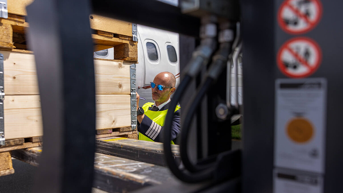 Flugkapitän kontrolliert und bestätigt die Beladung des Flugzeugs am Flughafen Hof-Plauen
