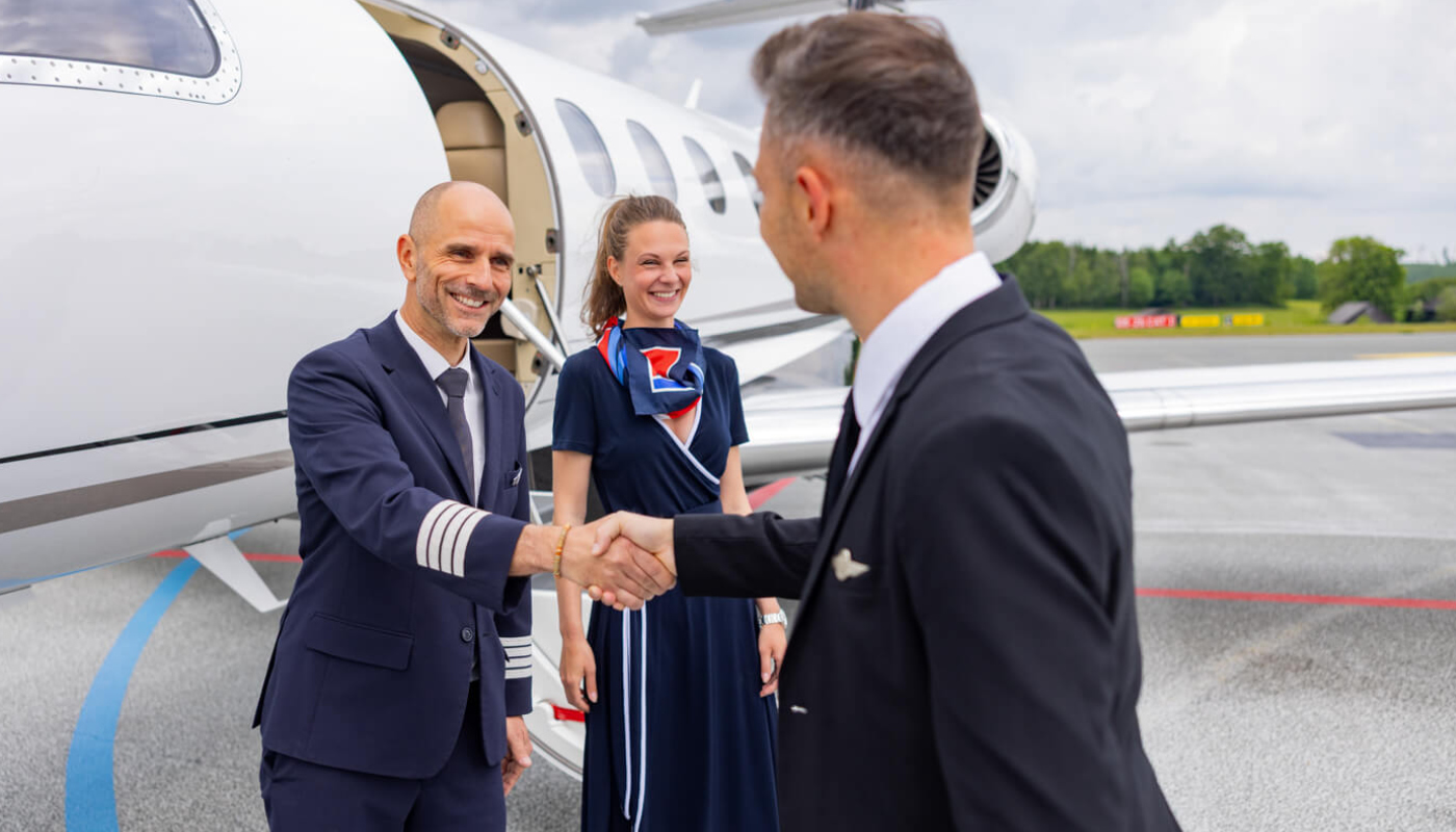 Stewardess und zwei Piloten vor einem Privatjet am Flughafen Hof-Plauen.